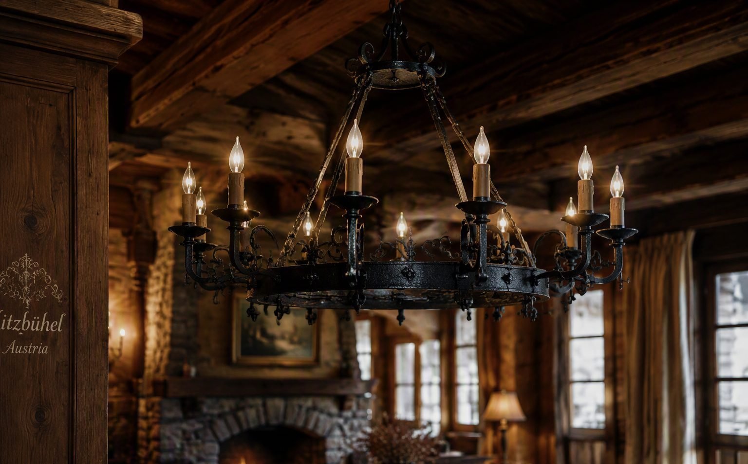 Wrought-iron chandelier hanging from timber beams inside a Kitzbühel alpine lodge